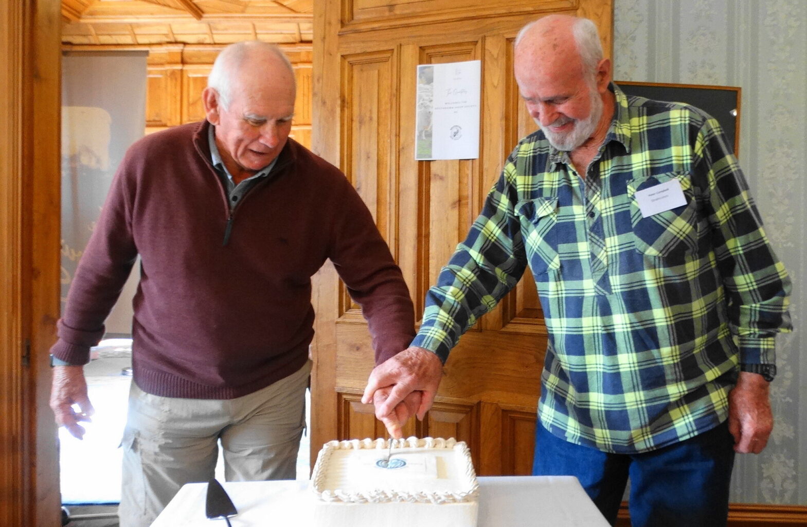 Life members John Wynyard and Peter Campbell cut the centennial cake.